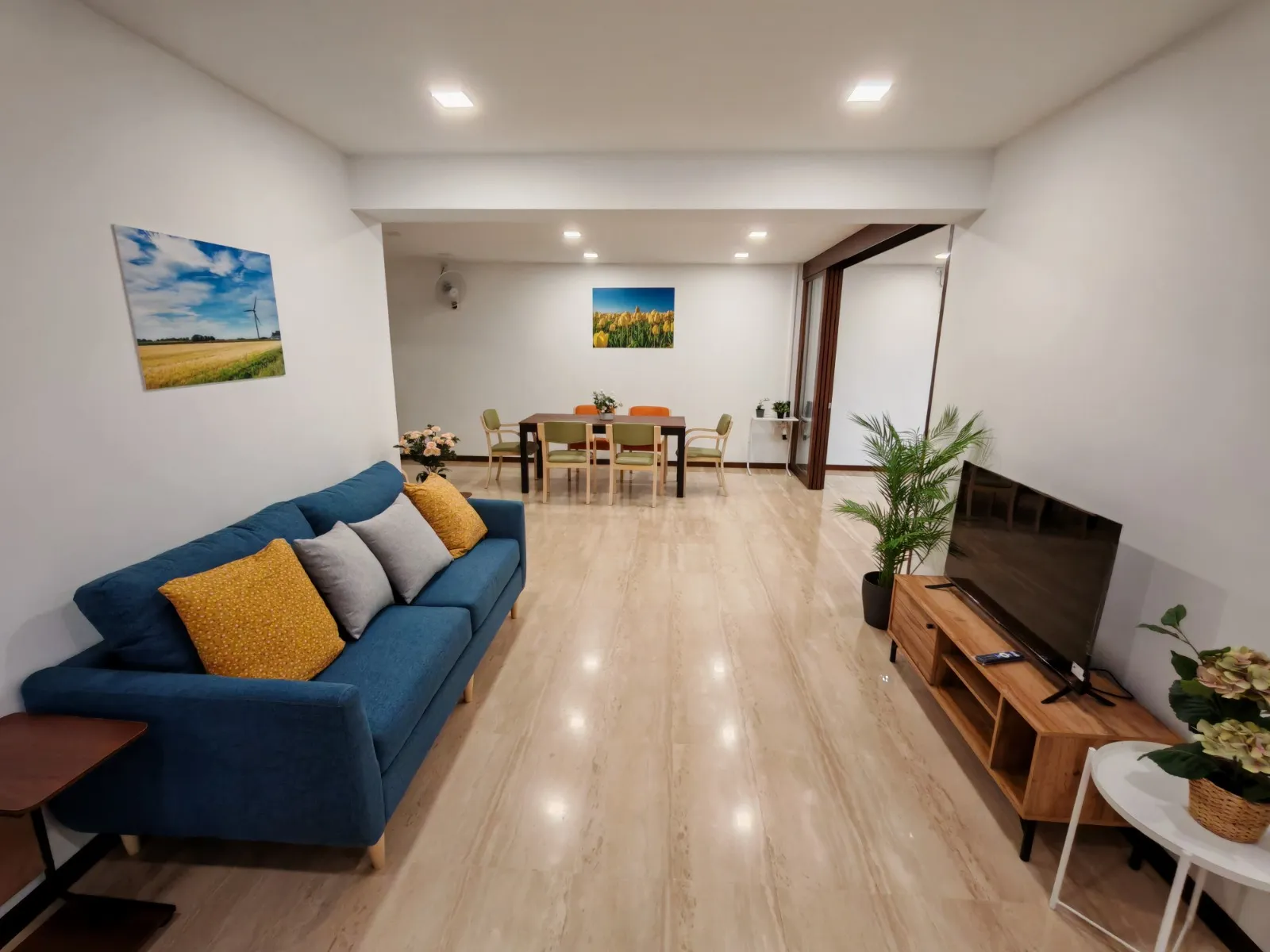 Blue Atria 后港住宿明亮的客厅，设有沙发、电视与用餐区